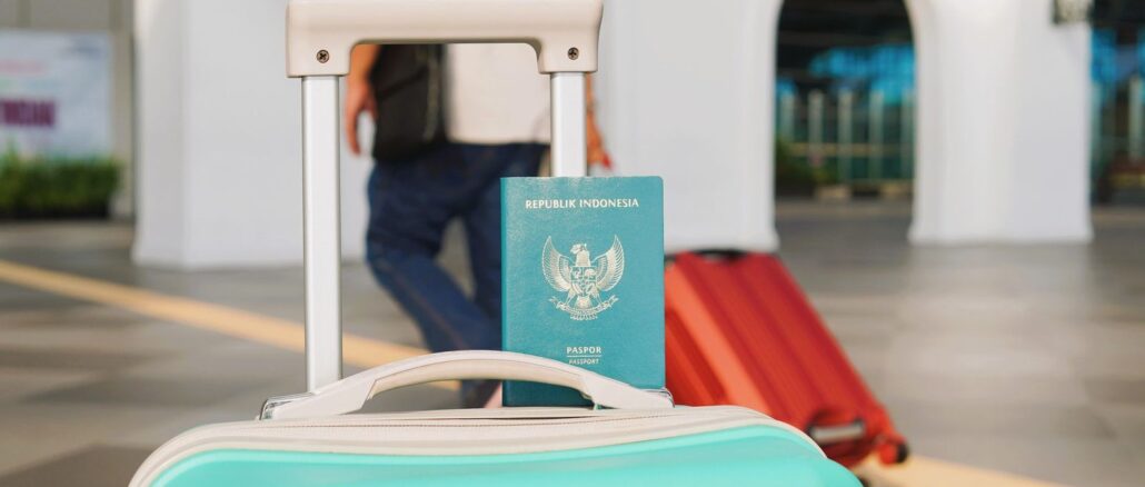 Versicherungsunterlagen neben Reisepass und Koffer